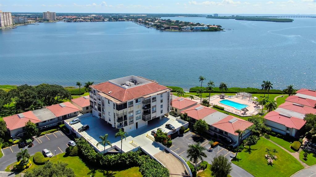 An aerial view shows a multi-story apartment building with a pool and parking lot — 6218 PALMA DEL MAR BOULEVARD S UNIT 606, ST PETERSBURG, FL