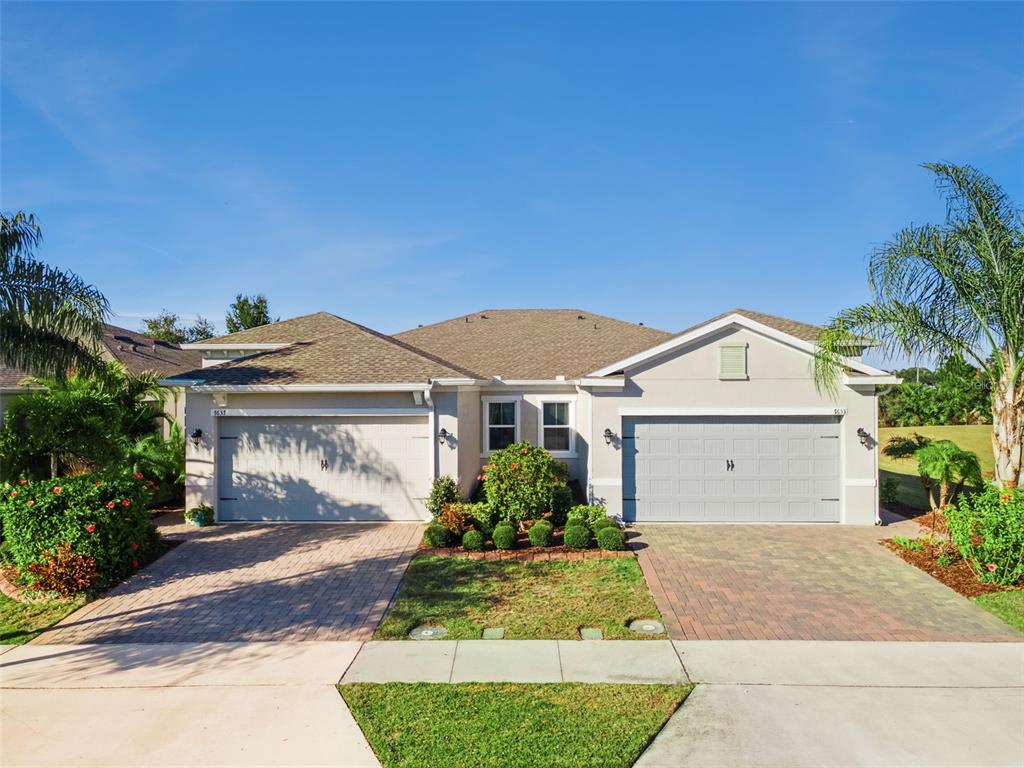 A single-story house with a two-car garage, a one-car garage, and a paved driveway — 7637 SAND PIERRE COURT, KISSIMMEE, FL