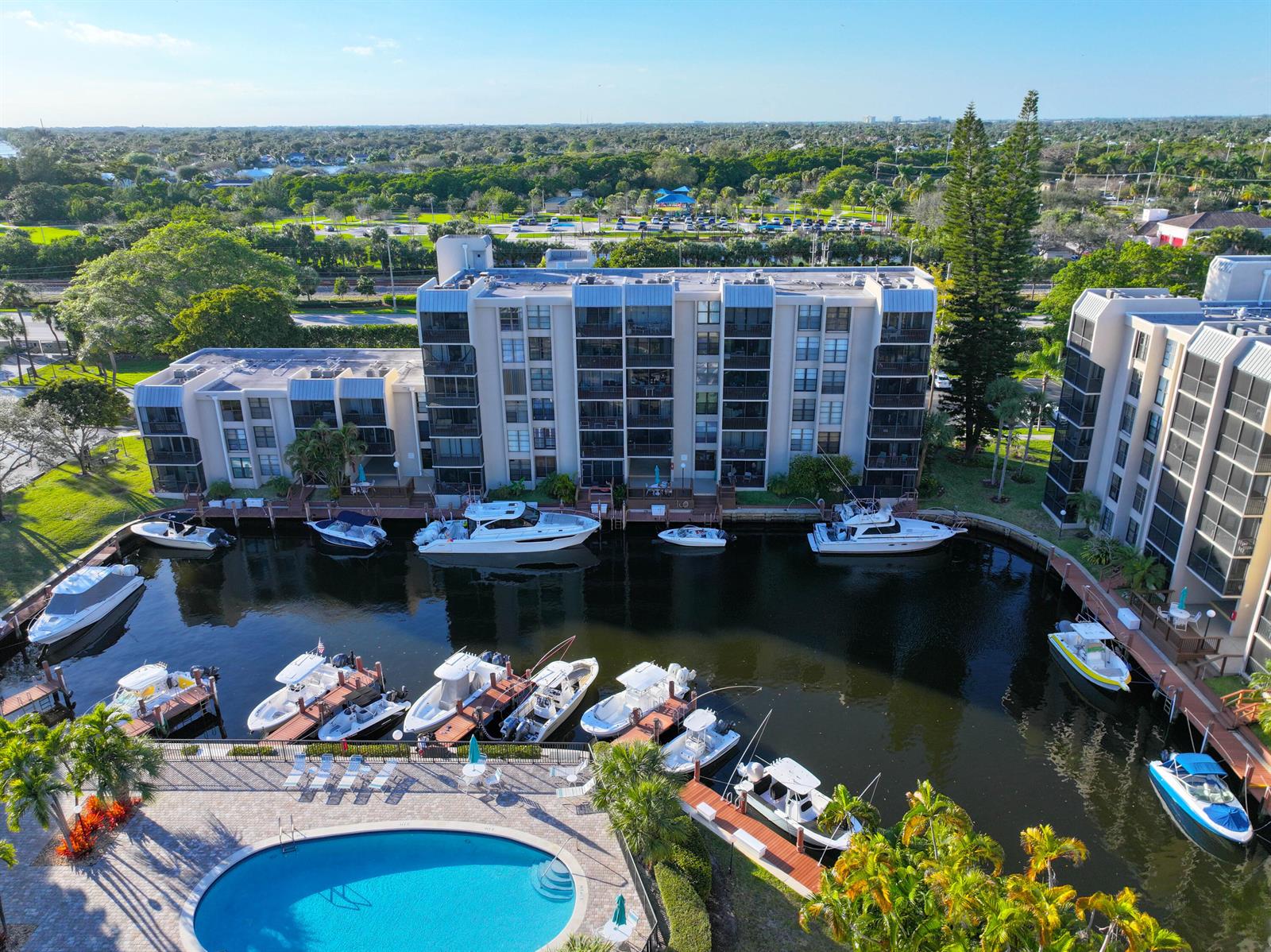An aerial view shows a multi-story apartment building with a pool and boat docks — 4 Royal Palm Way # 601, Boca Raton FL 33432, BOCA RATON, FL