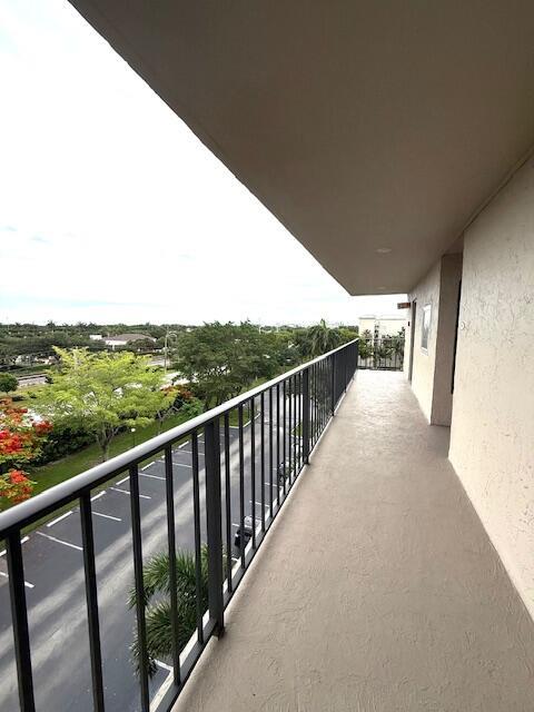 A balcony with a black metal railing overlooks a parking lot and green trees — 4 Royal Palm Way # 601, Boca Raton FL 33432, BOCA RATON, FL