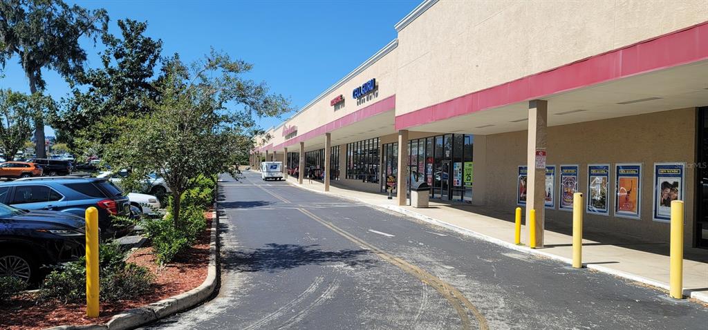A view of a commercial strip mall exterior with a parking lot and storefronts — 2019 E SILVER SPRINGS BOULEVARD, OCALA, FL