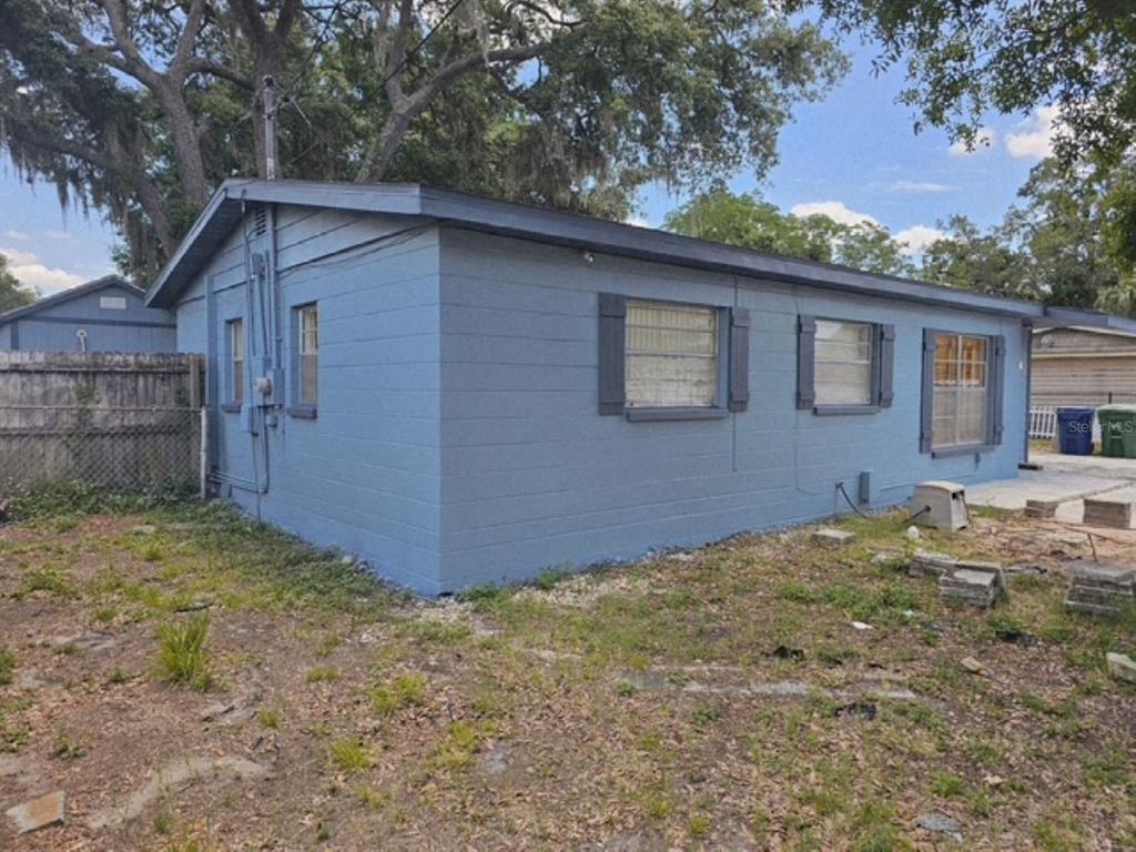 A blue concrete block house with a gabled roof and three windows on the side — 10209 LOLA STREET, TAMPA, FL