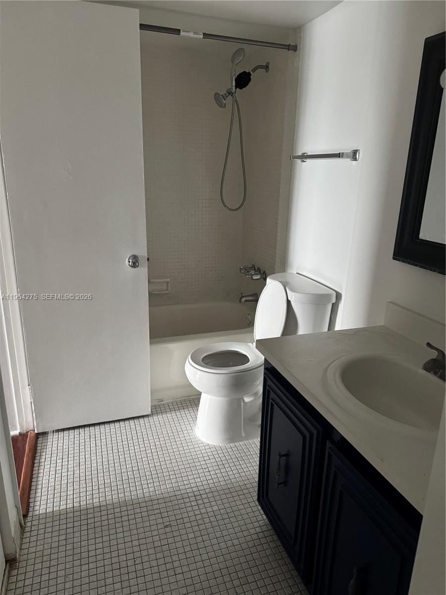A bathroom features a white toilet, a bathtub-shower combination, and a dark vanity cabinet — 496 NW 165th St Rd # 614, Miami FL 33169, MIAMI, FL