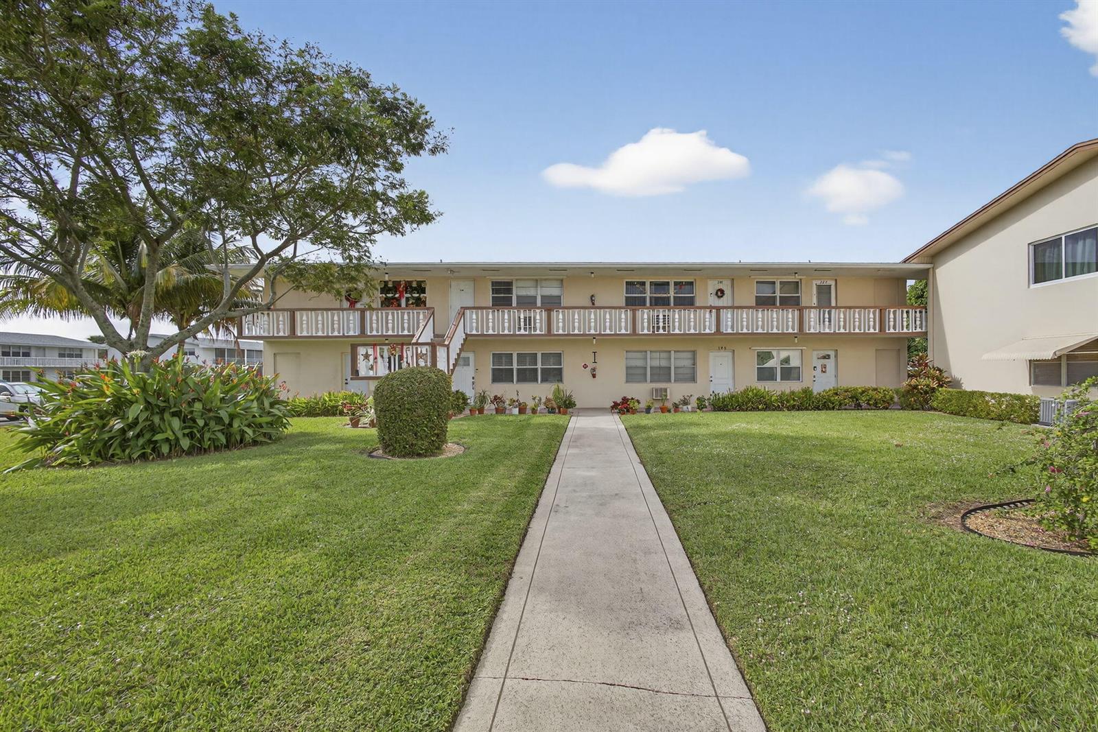 A two-story apartment building with a central walkway, lawn, and second-floor balcony — 193 Easthampton I, West Palm Beach FL 33417, WEST PALM BEACH, FL