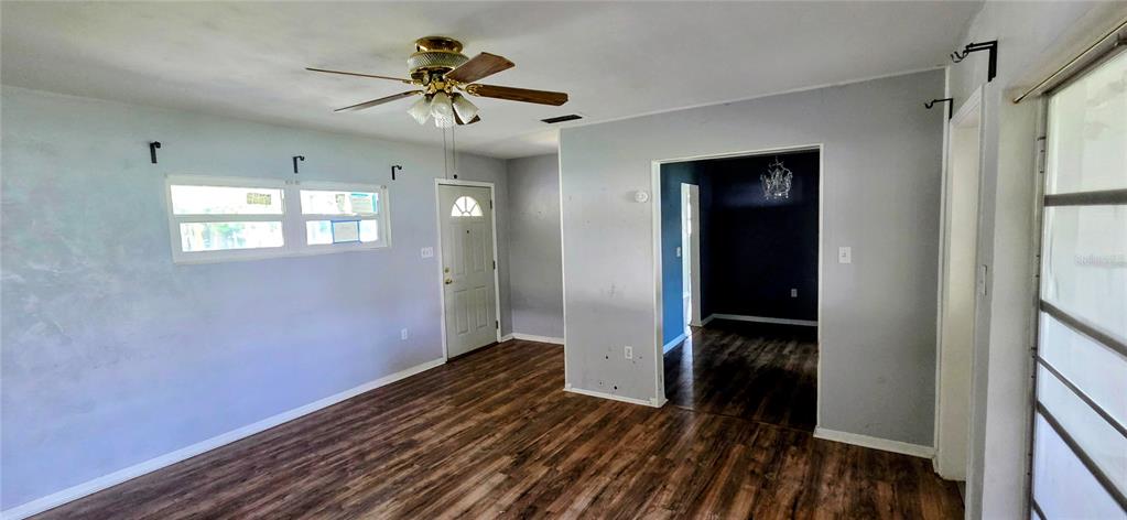 A living room features wood-look flooring, a ceiling fan, and a doorway leading to another room — 204 BOBBIE CIRCLE, LAKELAND, FL