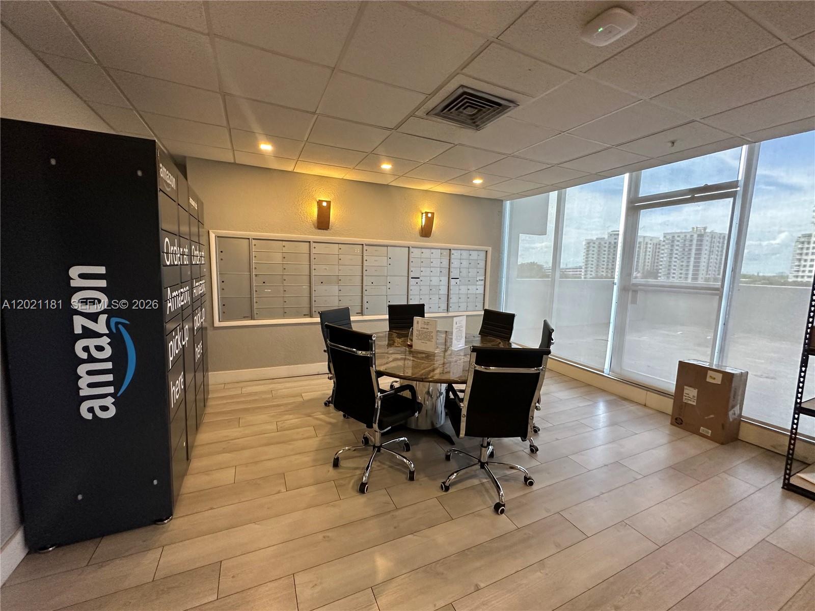 A room features an Amazon locker, a round conference table with chairs, and wall-mounted mailboxes — 1720 Harrison St # 5A, Hollywood FL 33020, HOLLYWOOD, FL