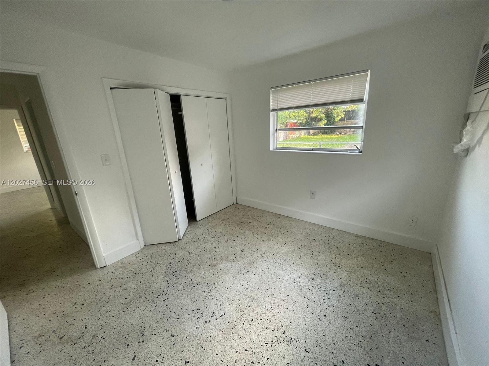 A bedroom features white walls, a window with blinds, a closet, and terrazzo flooring — 1032 SW 10th St, Miami FL 33130, MIAMI, FL