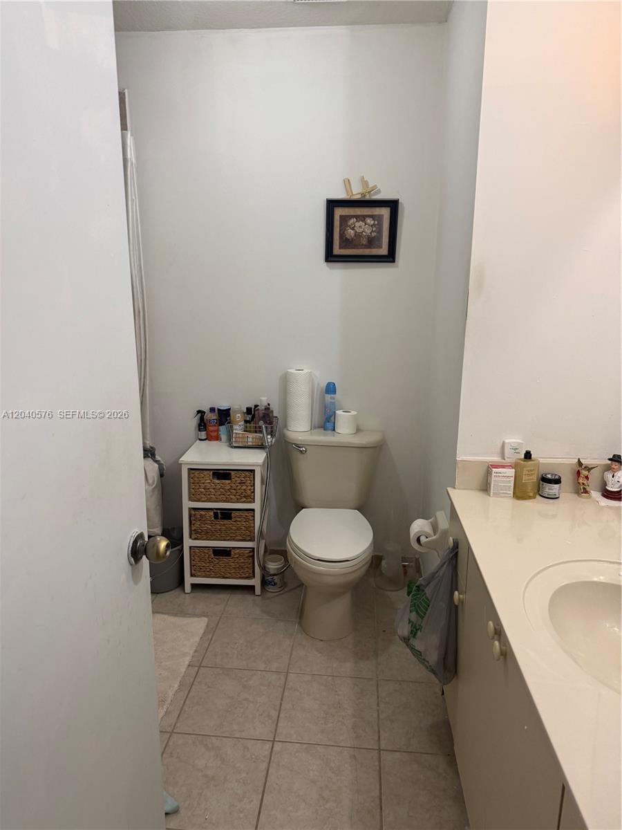 A bathroom features a toilet, a small three-drawer storage unit, and a vanity countertop — 5943 SW 162nd Pl, Miami FL 33193, MIAMI, FL