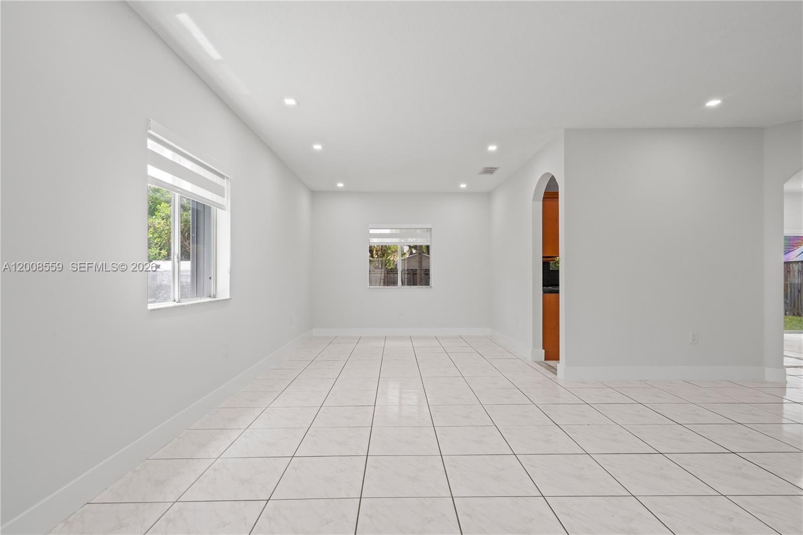A bright, empty room features white walls, tiled floors, recessed lighting, and two windows — 9576 SW 162nd Path, Miami FL 33196, MIAMI, FL