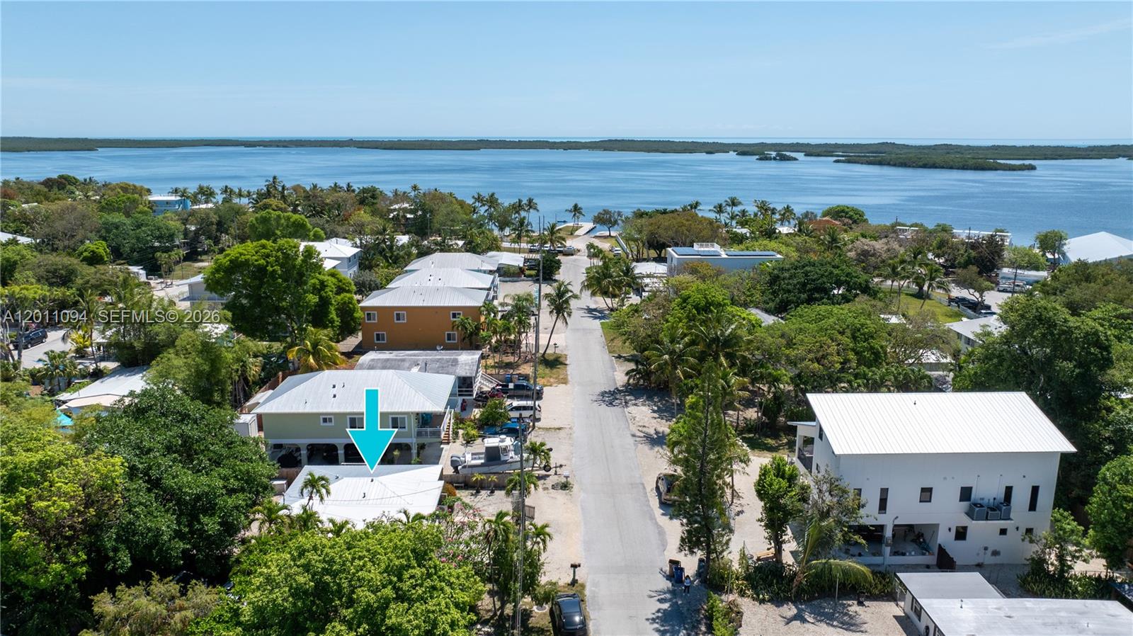 An aerial view shows a residential street leading toward a bay with several houses — 56 SE Marlin Ave, Key Largo FL 33037, KEY LARGO, FL