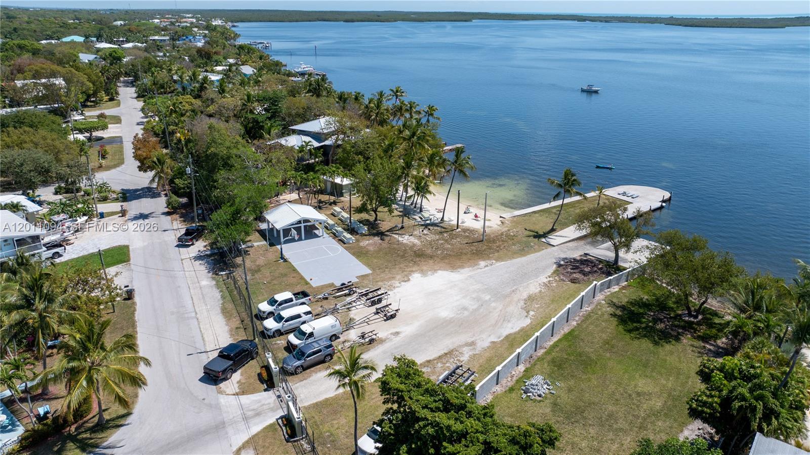 An aerial view shows a waterfront property with a boat ramp, dock, and basketball court — 56 SE Marlin Ave, Key Largo FL 33037, KEY LARGO, FL