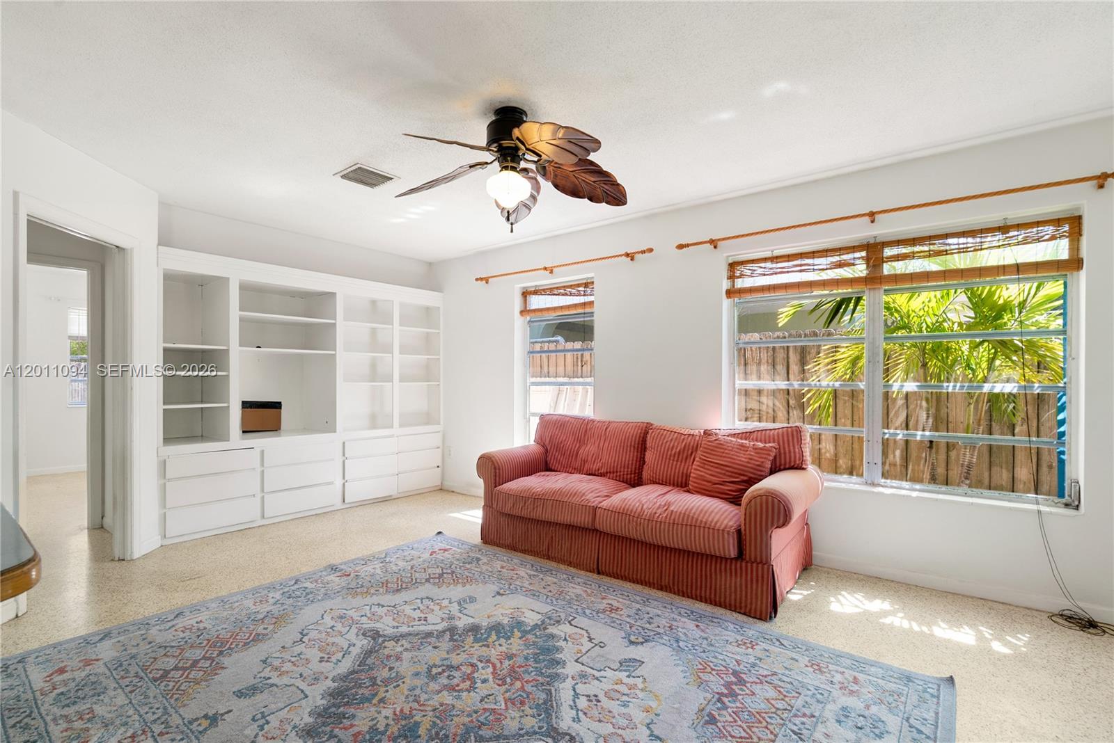 A living room features a striped sofa, built-in white shelving, and a palm-leaf ceiling fan — 56 SE Marlin Ave, Key Largo FL 33037, KEY LARGO, FL