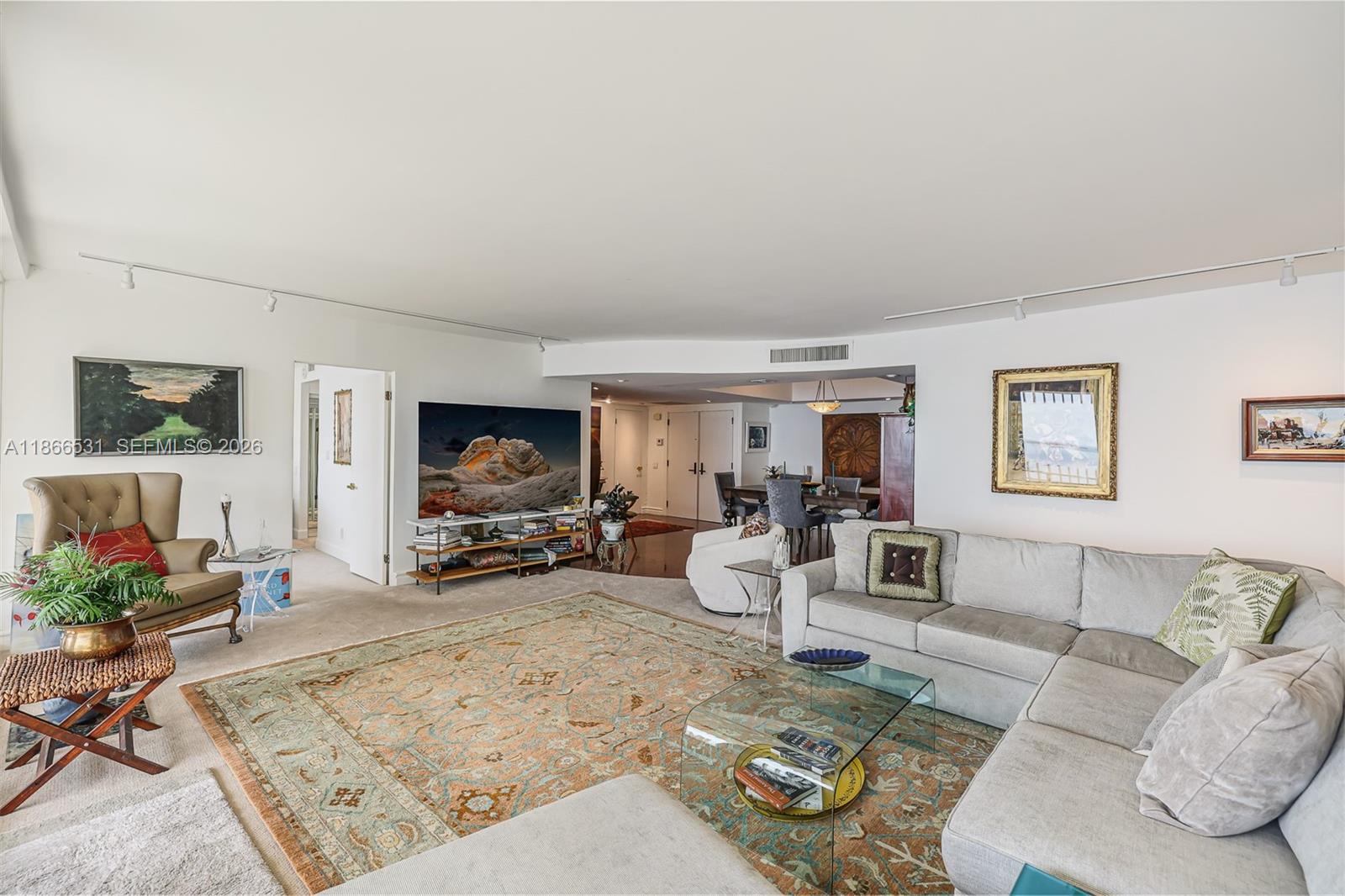 A living room features a large sectional sofa, an area rug, and a television console — 2 Grove Isle Dr # B1603, Miami FL 33133, MIAMI, FL
