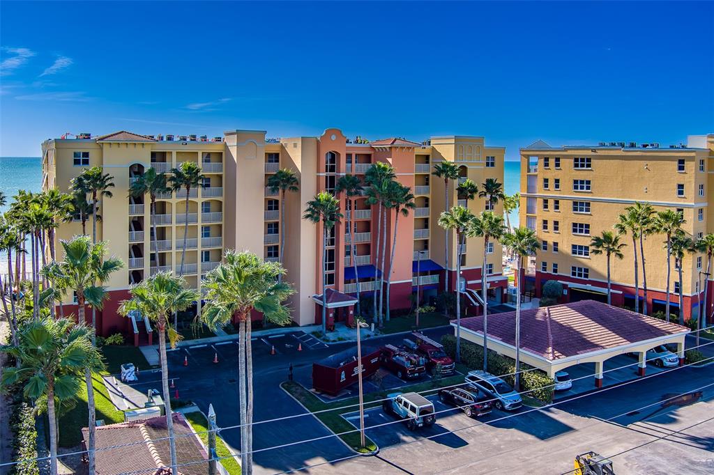 A view of a sandy beach and ocean from a balcony with palm trees — 16450 GULF BOULEVARD UNIT 565, NORTH REDINGTON BEACH, FL