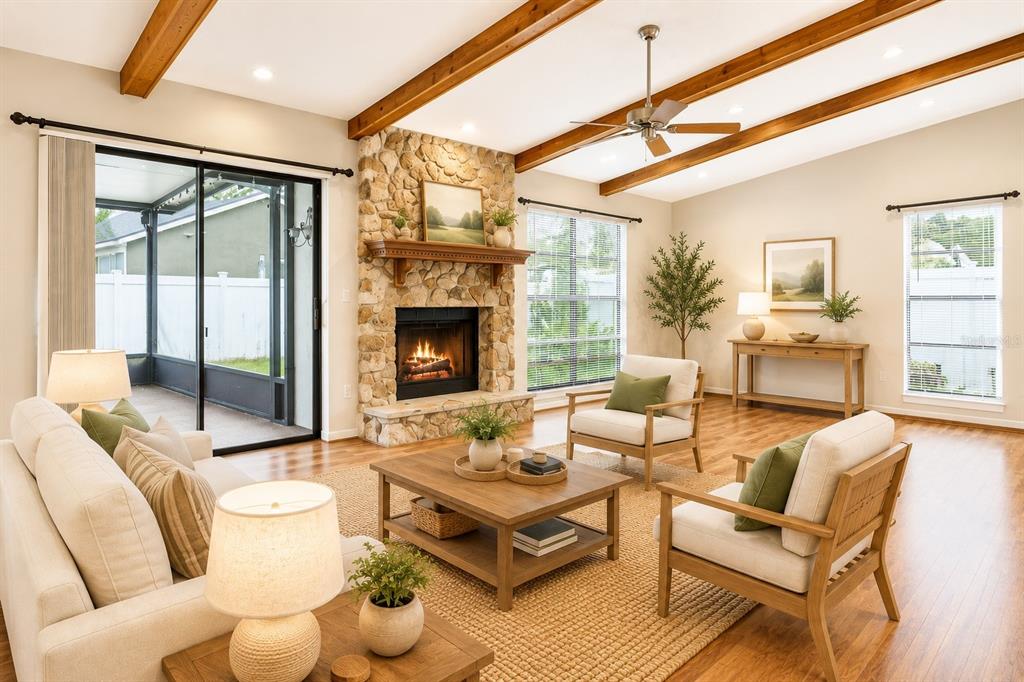 A living room features a stone fireplace, wood ceiling beams, and a sliding glass door — 787 EVERT COURT, WINTER SPRINGS, FL