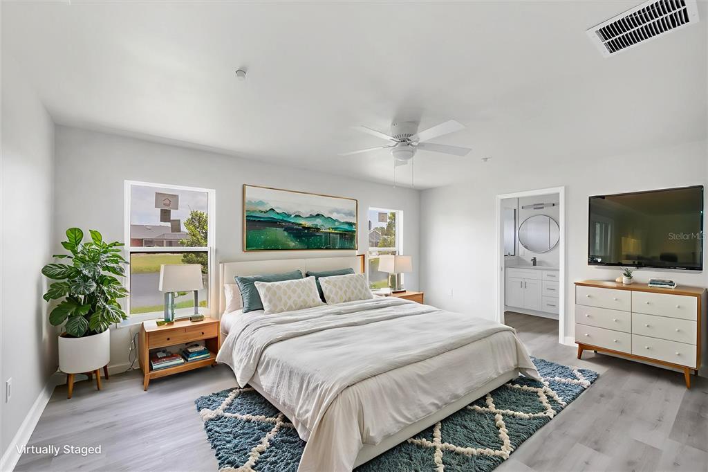 A bedroom features a bed, a dresser with a television, and an attached bathroom — 234 BOUNDARY BOULEVARD, ROTONDA WEST, FL