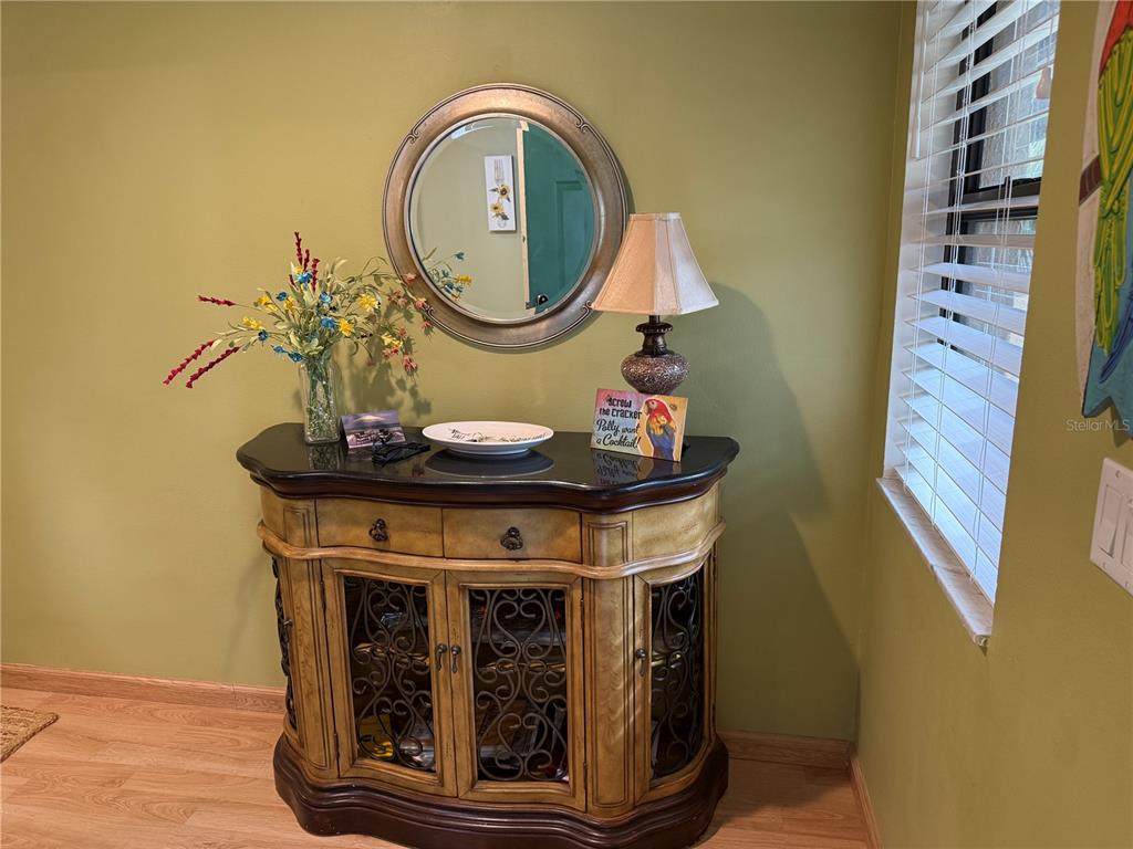 A wooden sideboard with a black top sits against a green wall under a mirror — 5770 ASHTON LAKE DRIVE UNIT 8, SARASOTA, FL
