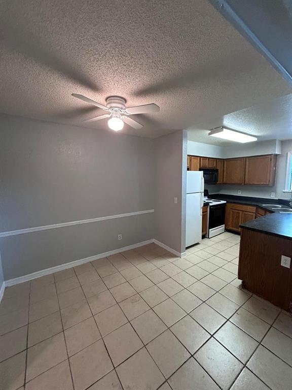 A dining area with a ceiling fan, tile flooring, and an adjacent kitchen with wood cabinets — 2948 ANTIQUE OAKS CIRCLE UNIT 94, WINTER PARK, FL