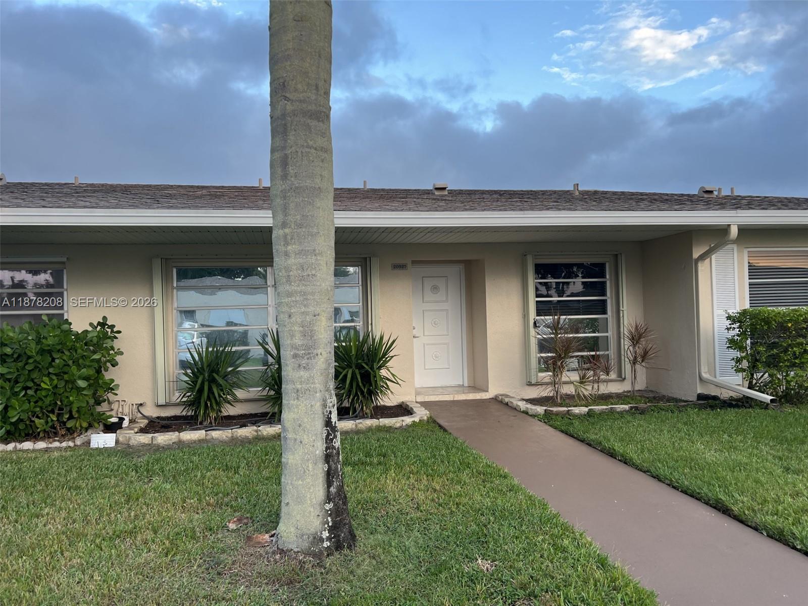 A single-story house exterior features a white front door, horizontal windows, and a palm tree — 20927 Sedgewick Dr # 20927, Boca Raton FL 33433, BOCA RATON, FL
