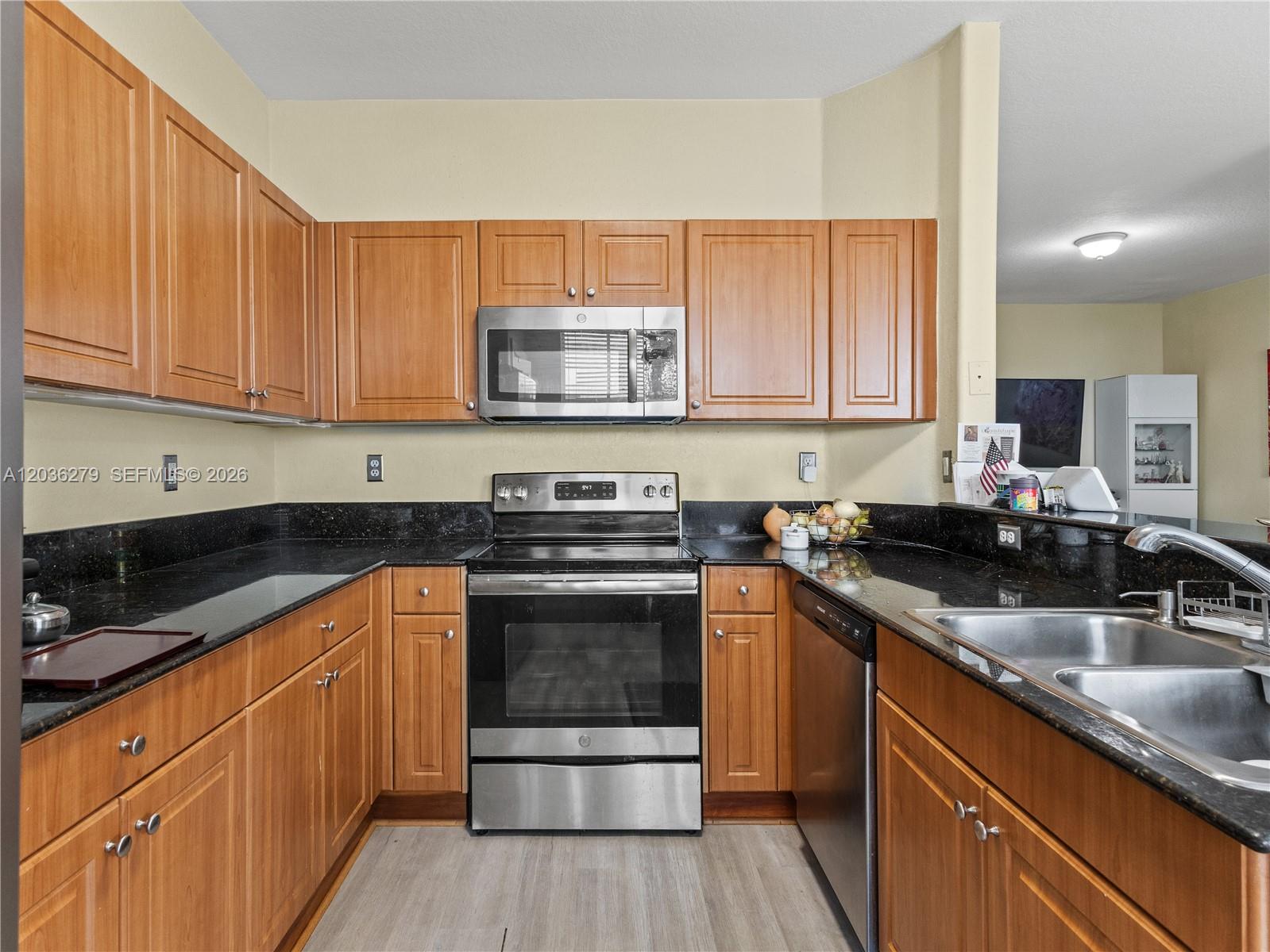 A kitchen with wood cabinets, black granite countertops, and stainless steel appliances — 8128 NW 108th Ct # 8128, Doral FL 33178, DORAL, FL