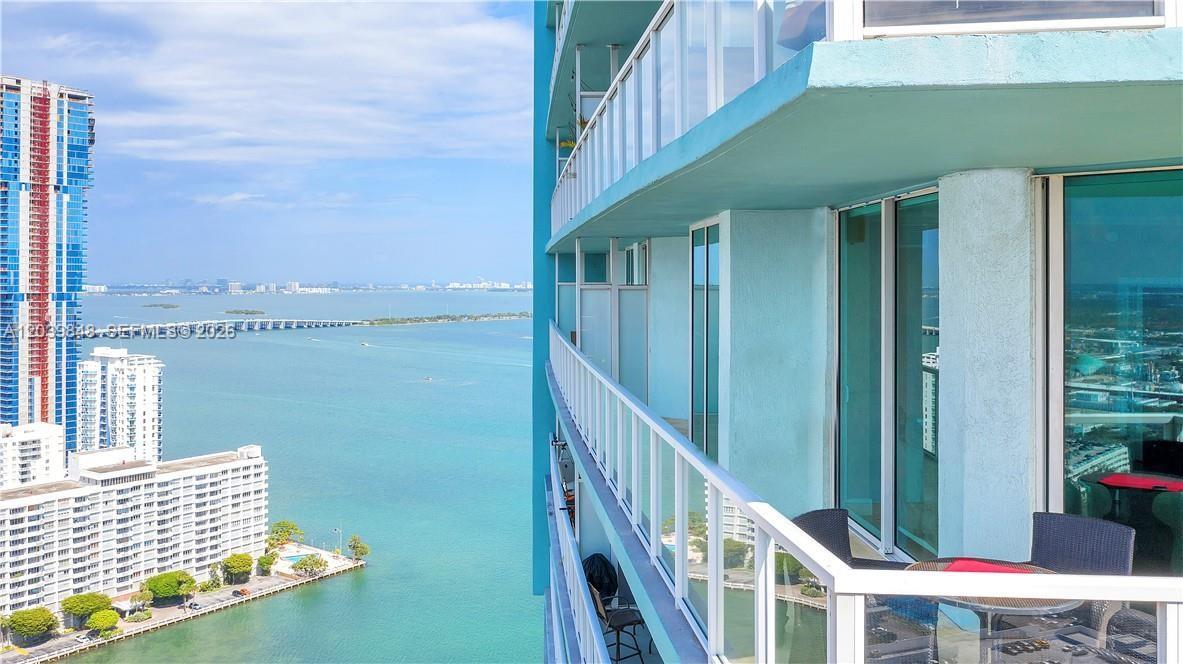 A high-rise balcony overlooks a bay with other tall buildings in the distance — 1900 N Bayshore Dr # 3518, Miami FL 33132, MIAMI, FL