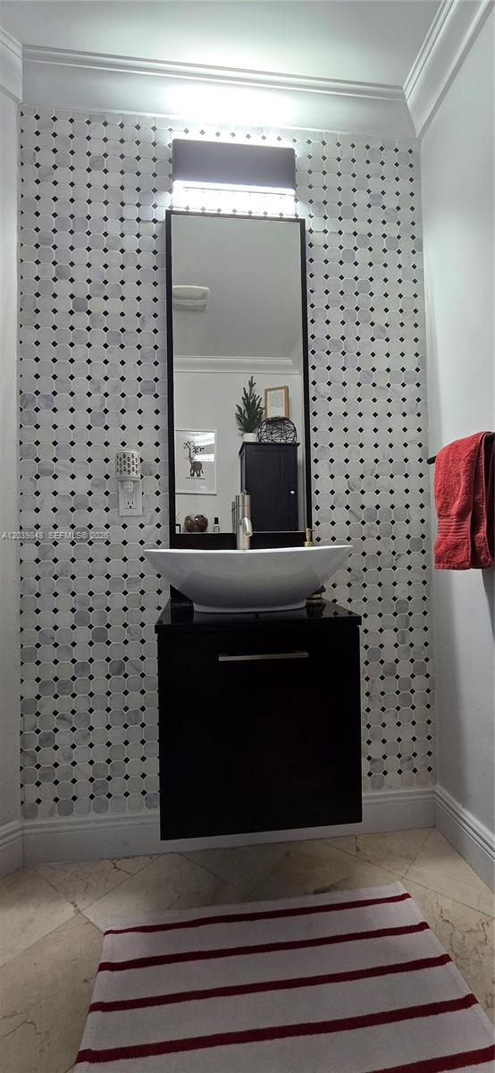 A modern bathroom features a vessel sink, black floating vanity, and marble mosaic tile wall — 1900 N Bayshore Dr # 3518, Miami FL 33132, MIAMI, FL