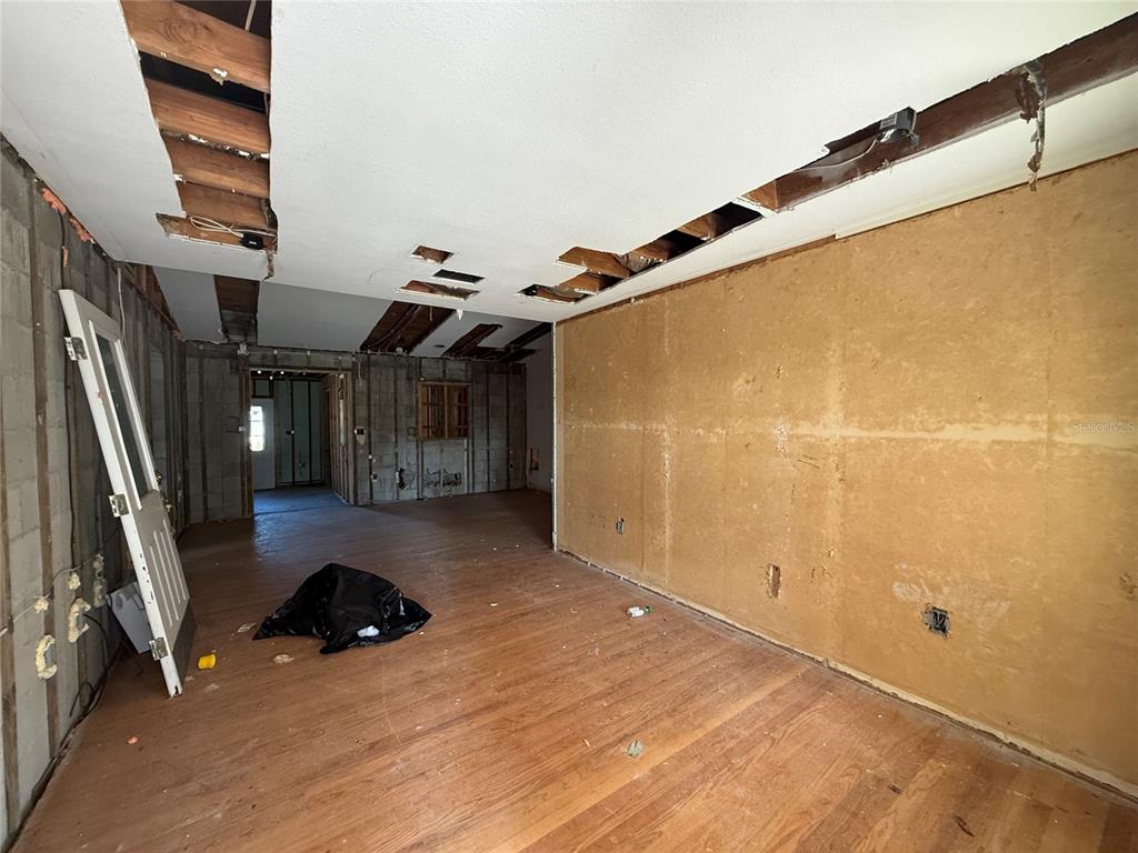 An interior room undergoing renovation with exposed ceiling joists and unfinished wall surfaces — 1015 S PALM AVENUE, ORLANDO, FL
