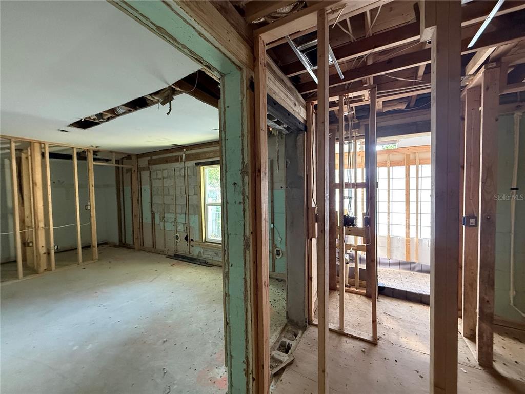 An interior view of a house under renovation showing exposed wall studs and concrete floors — 1015 S PALM AVENUE, ORLANDO, FL