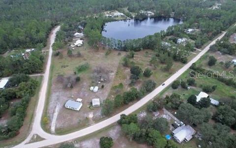 An aerial view shows a rural property with a house, outbuildings, and a nearby lake — 116 OSCEOLA ROAD, GEORGETOWN, FL