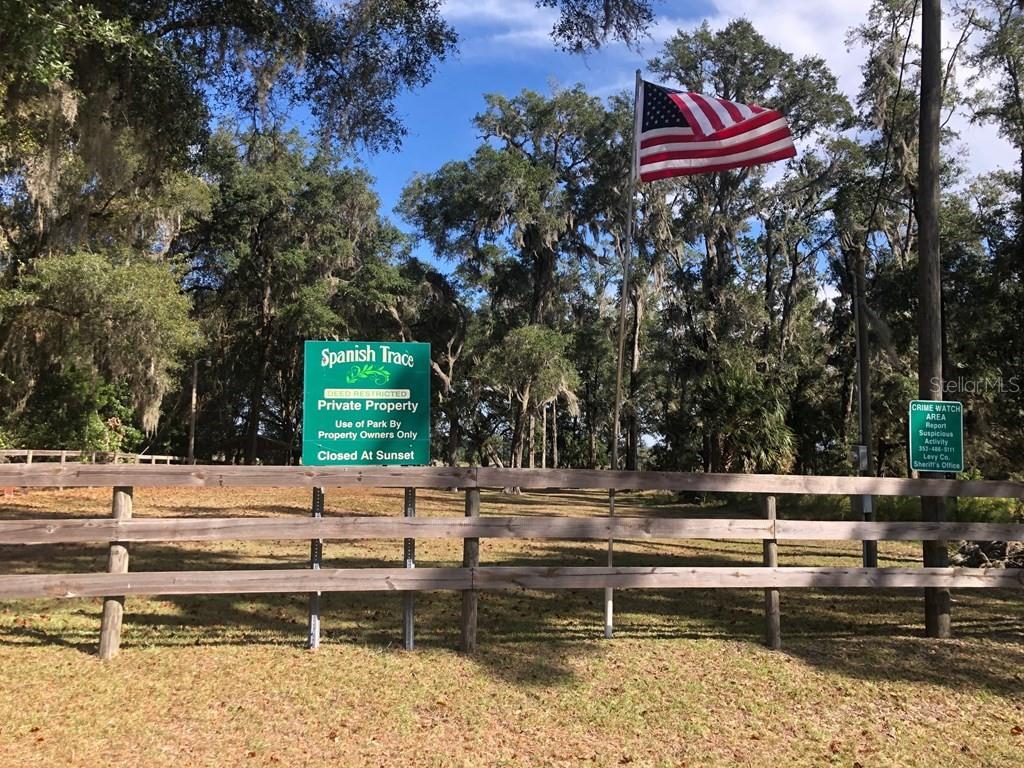 A wooden fence stands in front of a park sign and an American flag — 1.77 acres NW 73 STREET, CHIEFLAND, FL