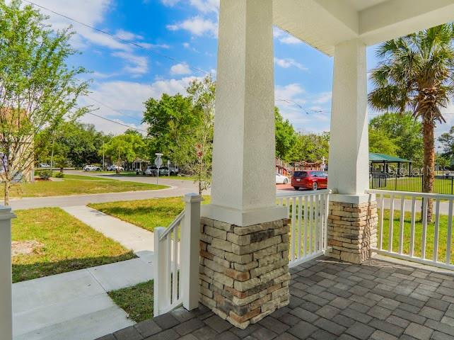 A view from a covered porch featuring stone-based pillars and a paved floor — 38 S POLLARD STREET, OAKLAND, FL