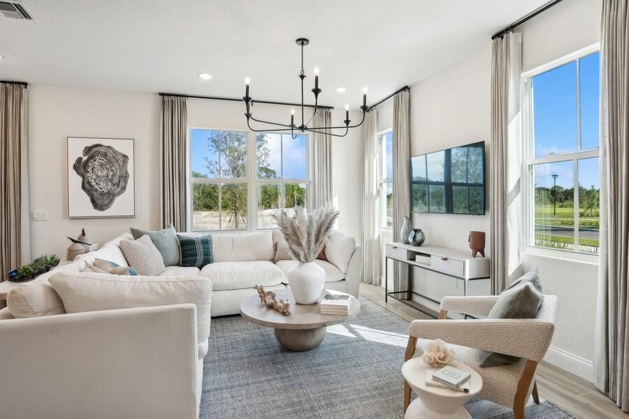 A bright living room features a white sectional sofa, a round coffee table, and windows — 194 SE Birch Terrace # 0316, Stuart FL 34997, STUART, FL