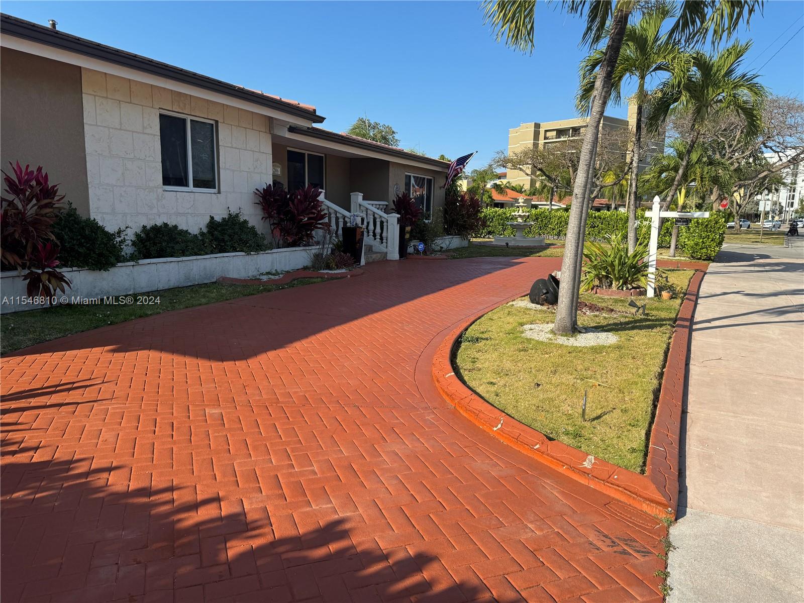 A house exterior features a red brick driveway, a small lawn, and a palm tree — 206 Ponce De Leon Blvd, Coral Gables FL 33134, CORAL GABLES, FL