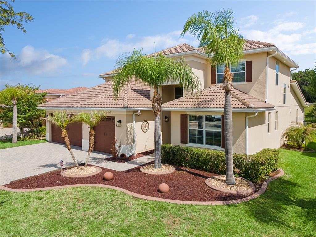A two-story stucco house with a tile roof, a two-car garage, and palm trees — 2341 EAGLE TALON COURT, KISSIMMEE, FL