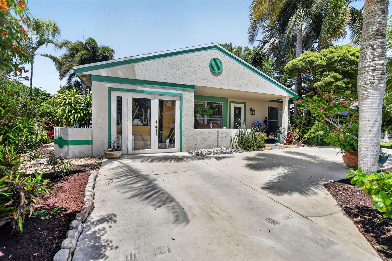 A single-story house with a concrete driveway, green trim, and a small front porch — 8353 Huntsman Place, Boca Raton FL 33433, BOCA RATON, FL