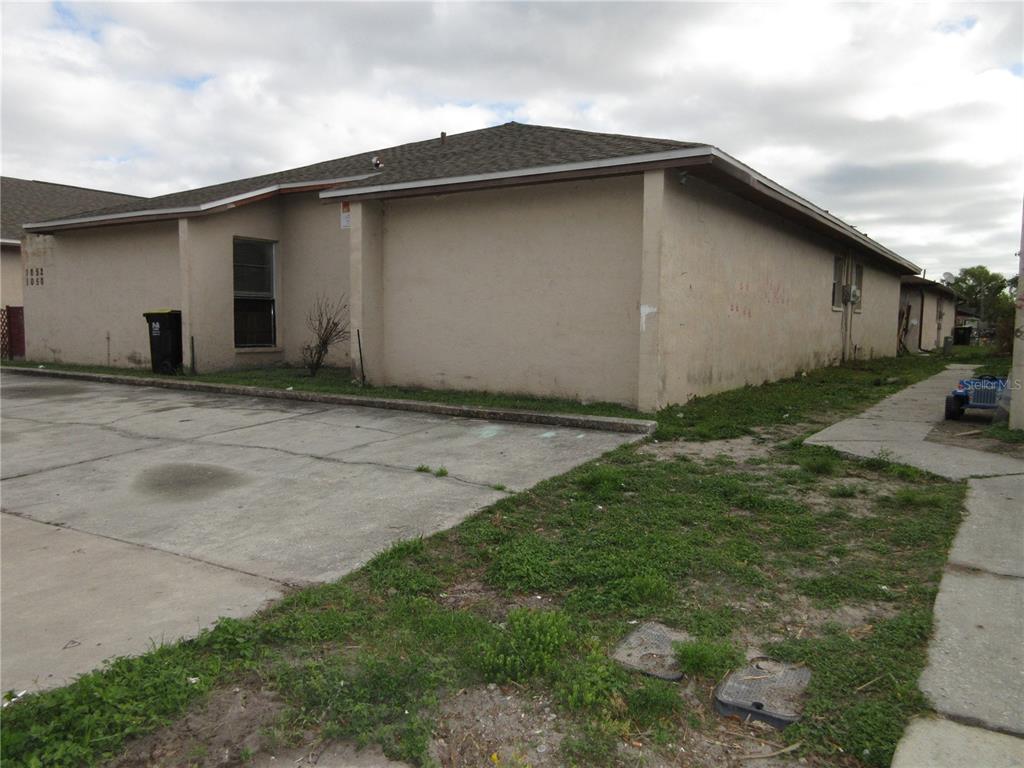 A tan, single-story building with a concrete driveway and a small patch of grass — 1050 CAPTIVA POINT, LAKELAND, FL