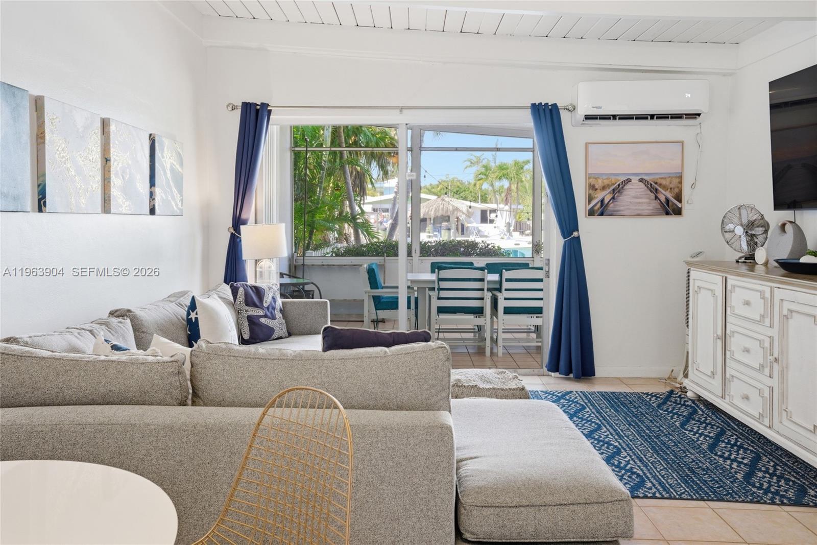 A living room features a sectional sofa, a blue rug, and a sliding glass door — 151 10th St, Marathon FL 33051, MARATHON, FL