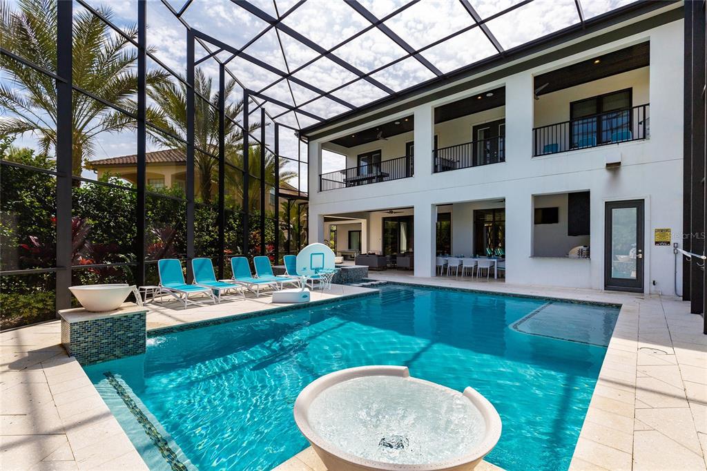 A screened-in patio features a swimming pool, a hot tub, and a two-story house exterior — 1200 GRAND TRAVERSE PARKWAY, REUNION, FL