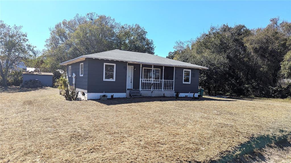 A gray, single-story house with a front porch sits on a large, dry grassy lot — 3425 IRENE STREET, MELBOURNE, FL