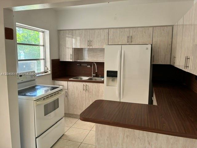 A kitchen features light wood-grain cabinets, a white refrigerator, a white stove, and brown countertops — 6741 SW 5th Ter, Miami FL 33144, MIAMI, FL