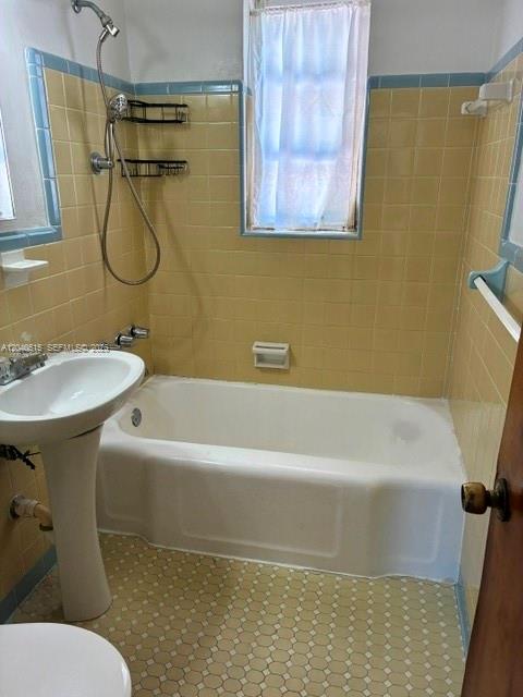 A bathroom features a pedestal sink, a white bathtub, and yellow tiled walls — 6741 SW 5th Ter, Miami FL 33144, MIAMI, FL