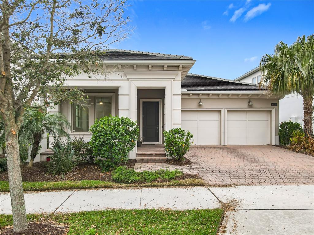 A single-story house with a two-car garage, a paved driveway, and a front entryway — 8325 TOPSAIL PLACE, WINTER GARDEN, FL