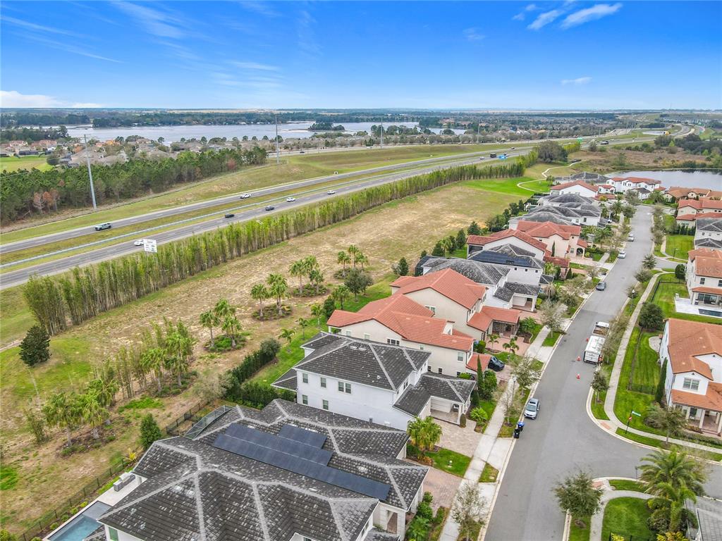 An aerial view shows a residential street with houses, a highway, and a large lake — 8325 TOPSAIL PLACE, WINTER GARDEN, FL
