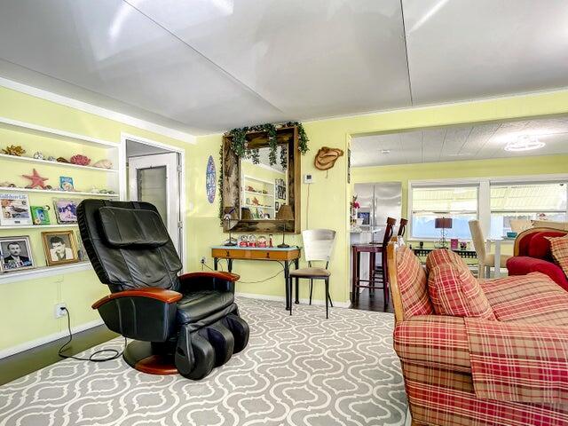 A living room features a black massage chair, a plaid sofa, and built-in wall shelving — 4215 Meadow View Drive, Boynton Beach FL 33436, BOYNTON BEACH, FL
