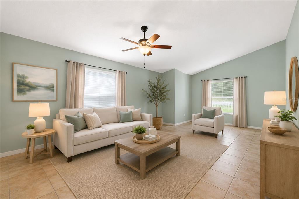 A living room features light green walls, a beige sofa, an armchair, and tile flooring — 3002 LORIMER CT, GROVELAND, FL