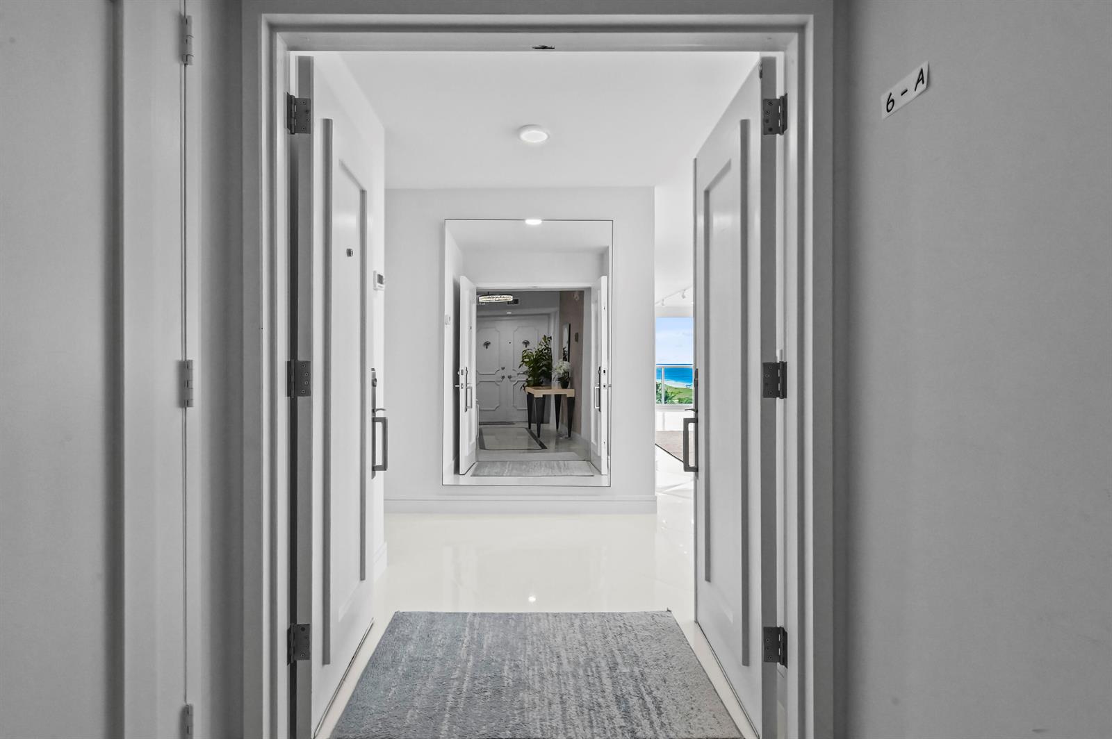A white entryway features double doors, a large wall mirror, and a view of the ocean — 2800 S Ocean Boulevard # A, Boca Raton FL 33432, BOCA RATON, FL