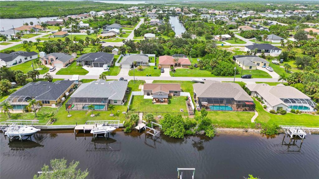 A single-story house with a light blue front door, a garage, and a green lawn — 4394 LIBRARY STREET, PORT CHARLOTTE, FL