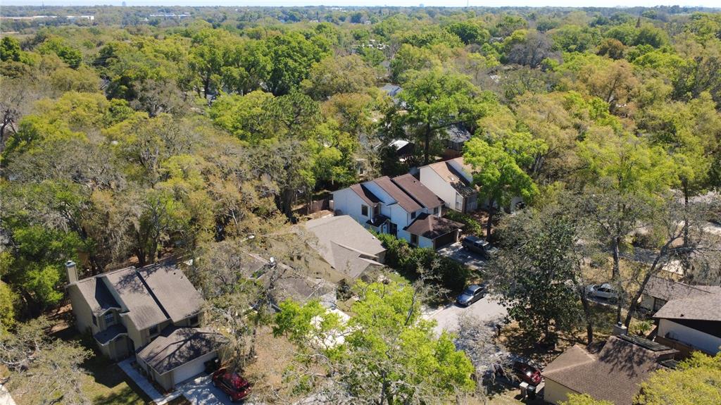 An aerial view shows several suburban houses surrounded by dense trees and greenery — 1777 SUMMIT CHASE AVENUE, APOPKA, FL