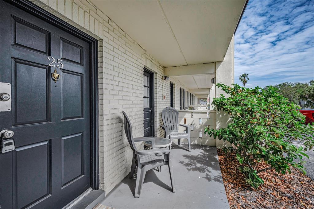 A black front door with the number 25 sits on a patio with two chairs — 2 N FERNWOOD AVENUE UNIT 25, CLEARWATER, FL