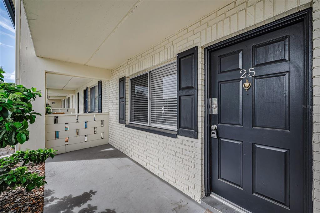 A front porch features a black door with the number 25 and a window with shutters — 2 N FERNWOOD AVENUE UNIT 25, CLEARWATER, FL